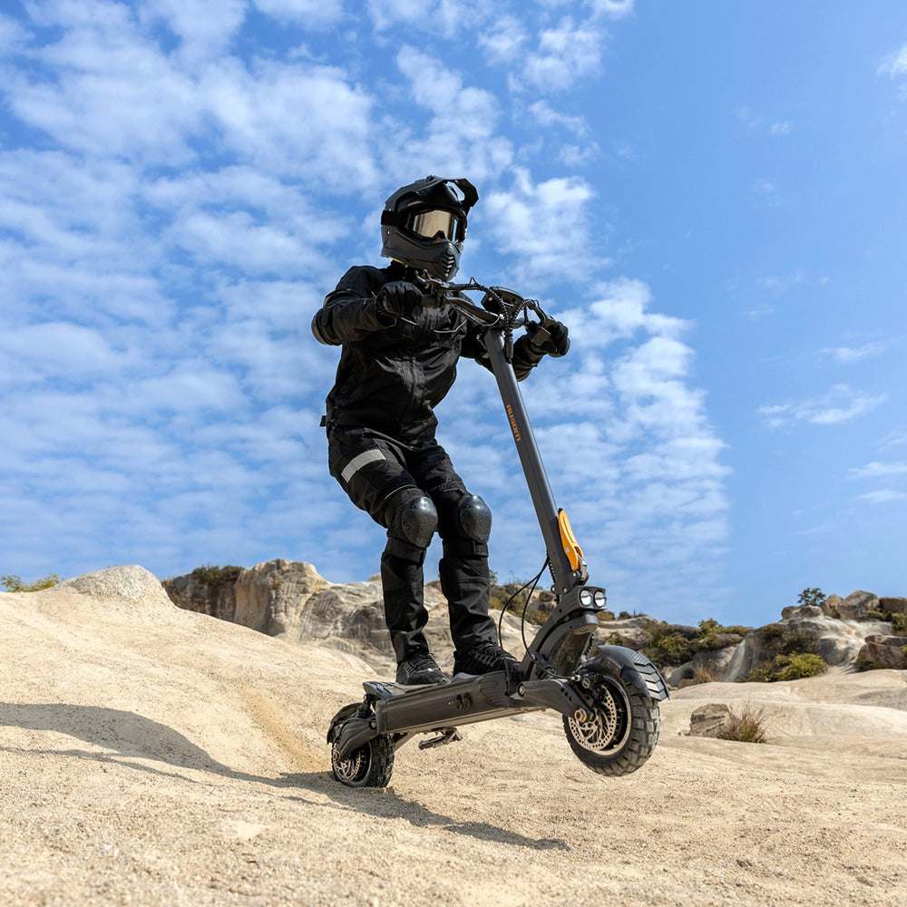 Person riding Ausom F1 Max Trottinette électrique off-road electric scooter with 1400W dual motors and 10-inch pneumatic tires under blue sky