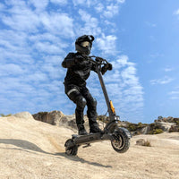 Person riding Ausom F1 Max Trottinette électrique off-road electric scooter with 1400W dual motors and 10-inch pneumatic tires under blue sky