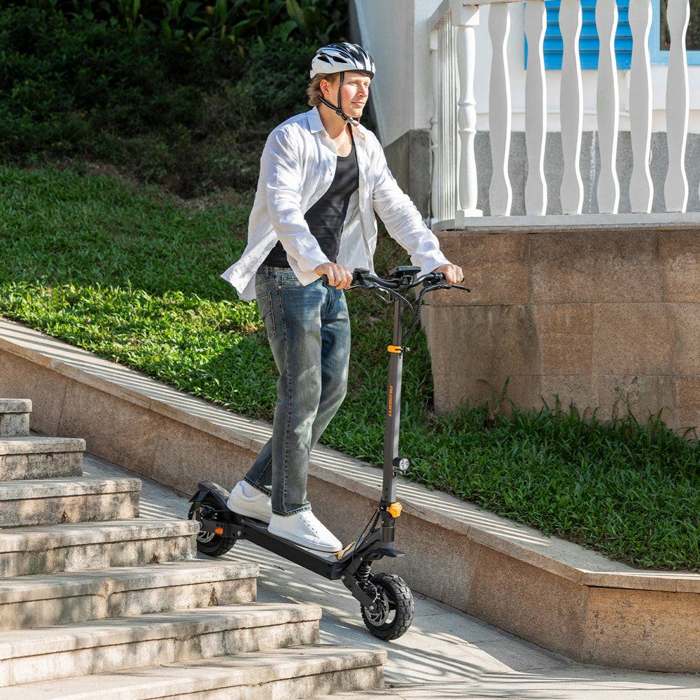 Man riding Ausom L1 Trottinette électrique electric scooter descending outdoor stairs with helmet and casual clothing