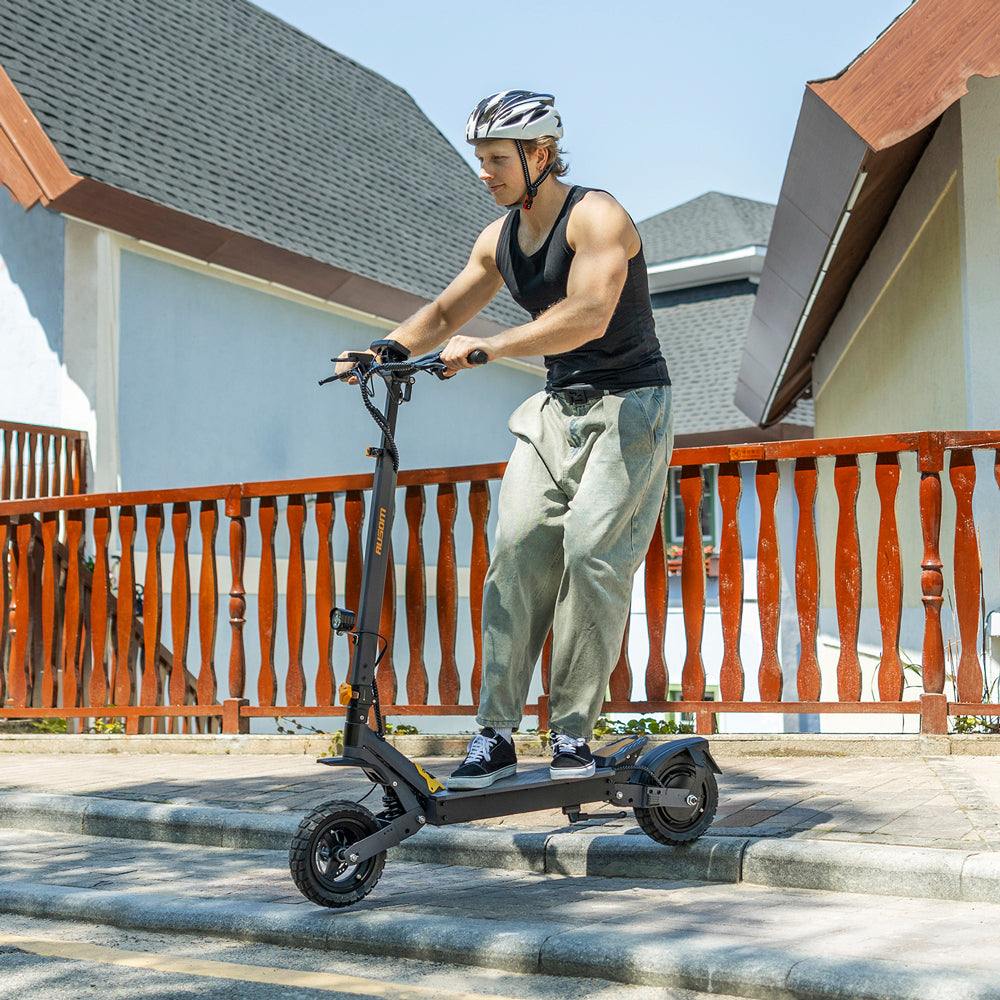 Man riding Ausom L1 Trottinette électrique electric scooter outdoors with helmet